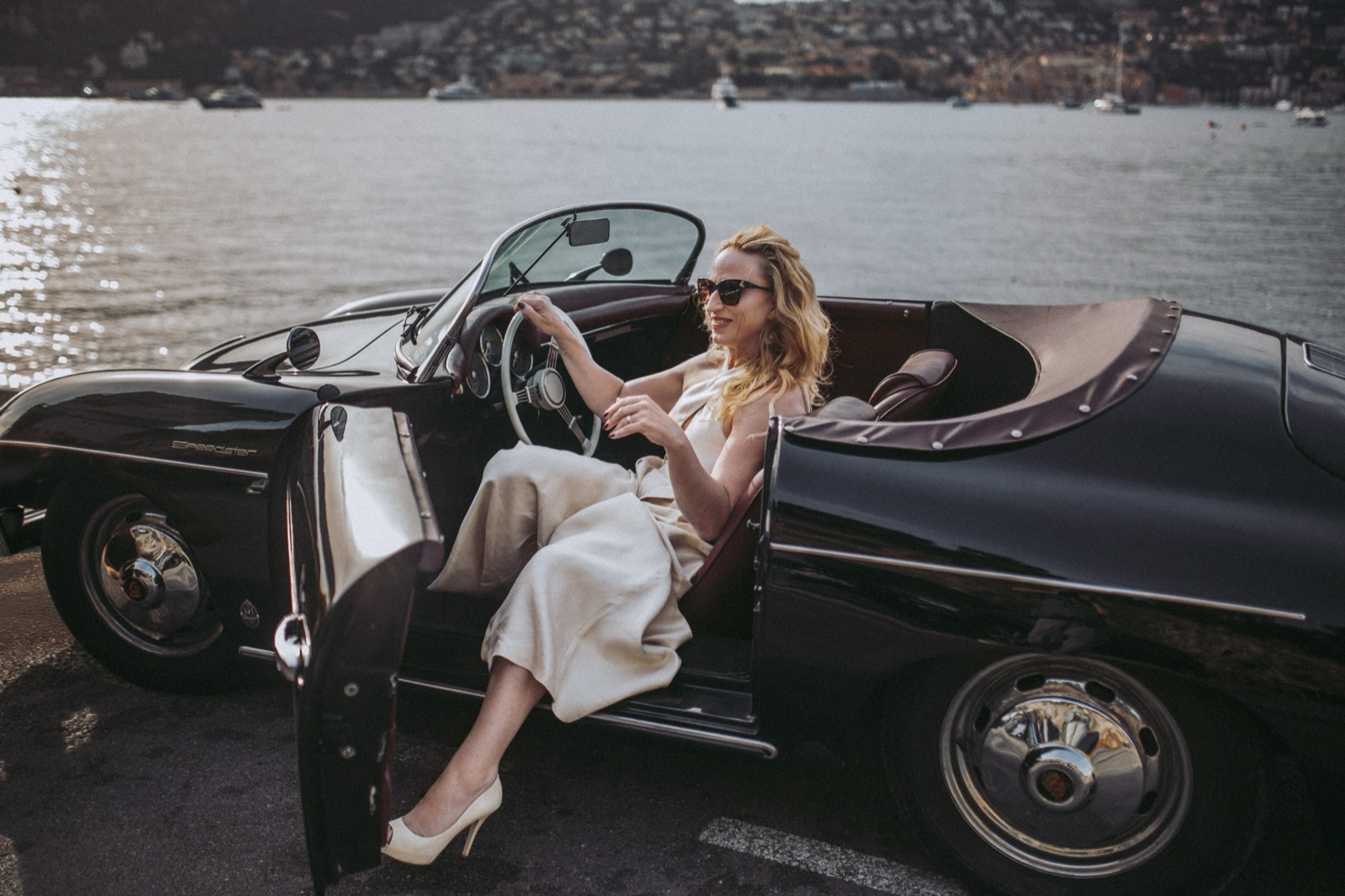 Birgit Fortunati am Steuer eines Oldtimer-Cabrios am Meer